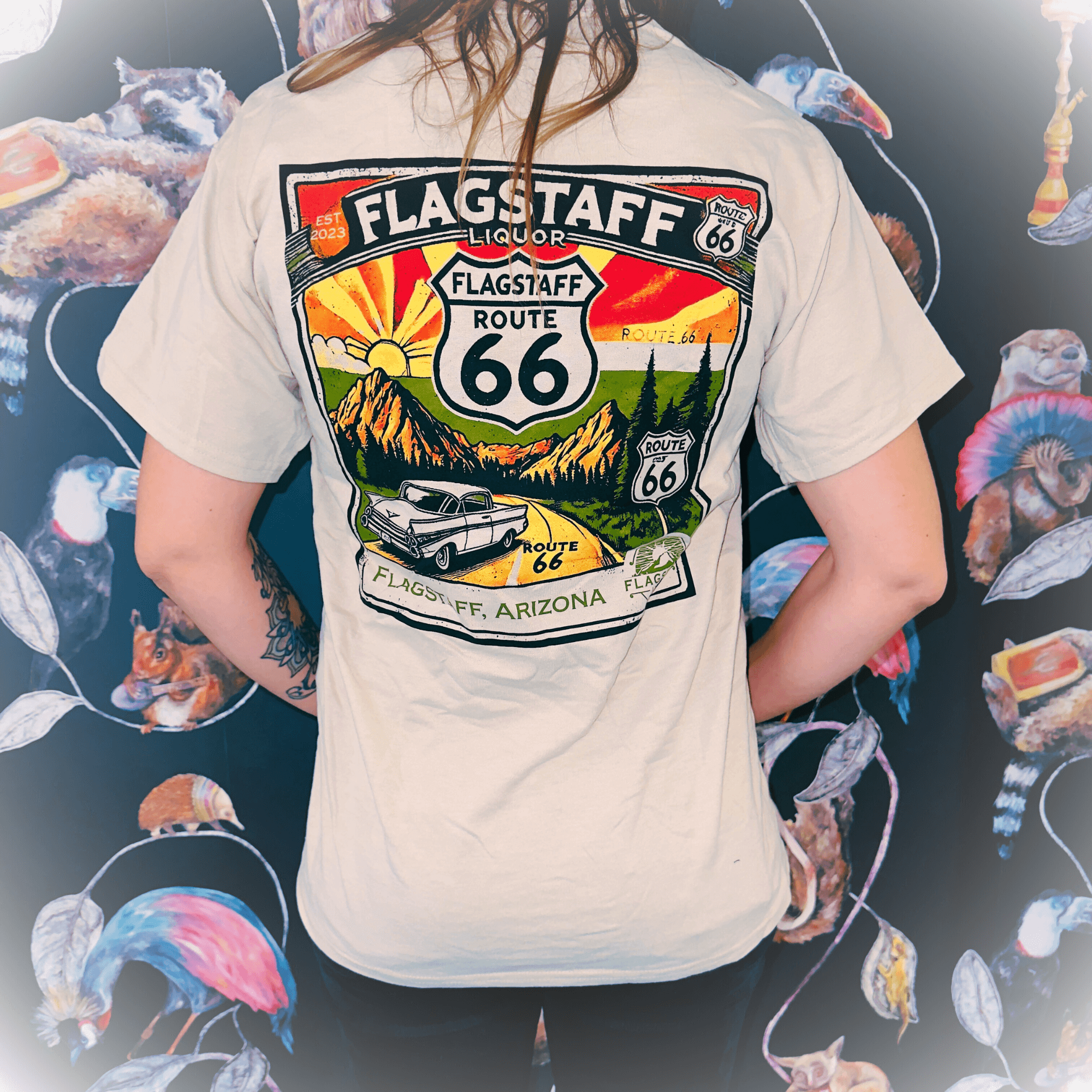 Back view of a person wearing a Flagstaff Liquor Route 66 T-Shirt, featuring a scenic design celebrating the iconic Mother Road.