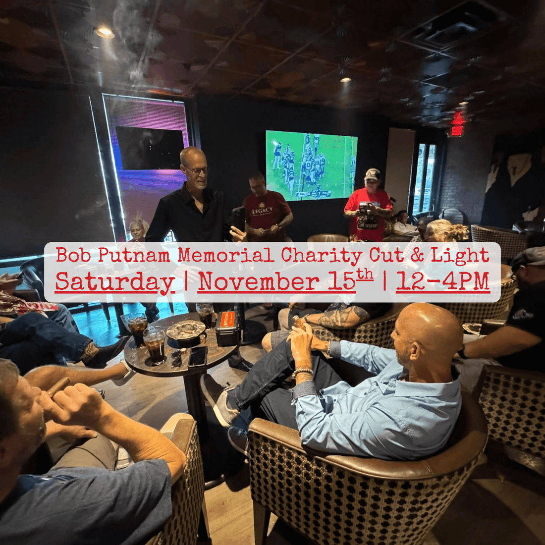 Bob Putnam, standing in black shirt, enjoying cigars with friends before his passing — a moment honoring his spirit and love of community.